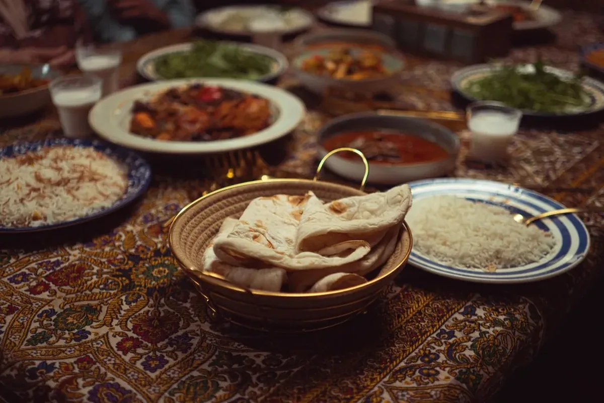 Table spread with flatbread, rice and stew dishes on a patterned tablecloth